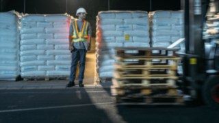 Lagerarebiter und Stapler kreuzen sich und der Lagerarebeiter ist mit der Interaktiven Warnweste von Linde Material Handling gut sichtbar