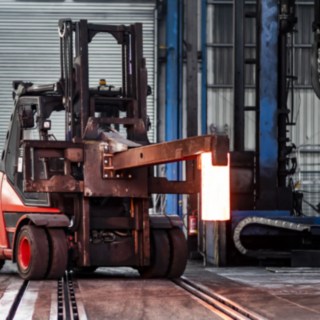 Das Gerät transportiert ein glühendes Eisen über das Gelände.